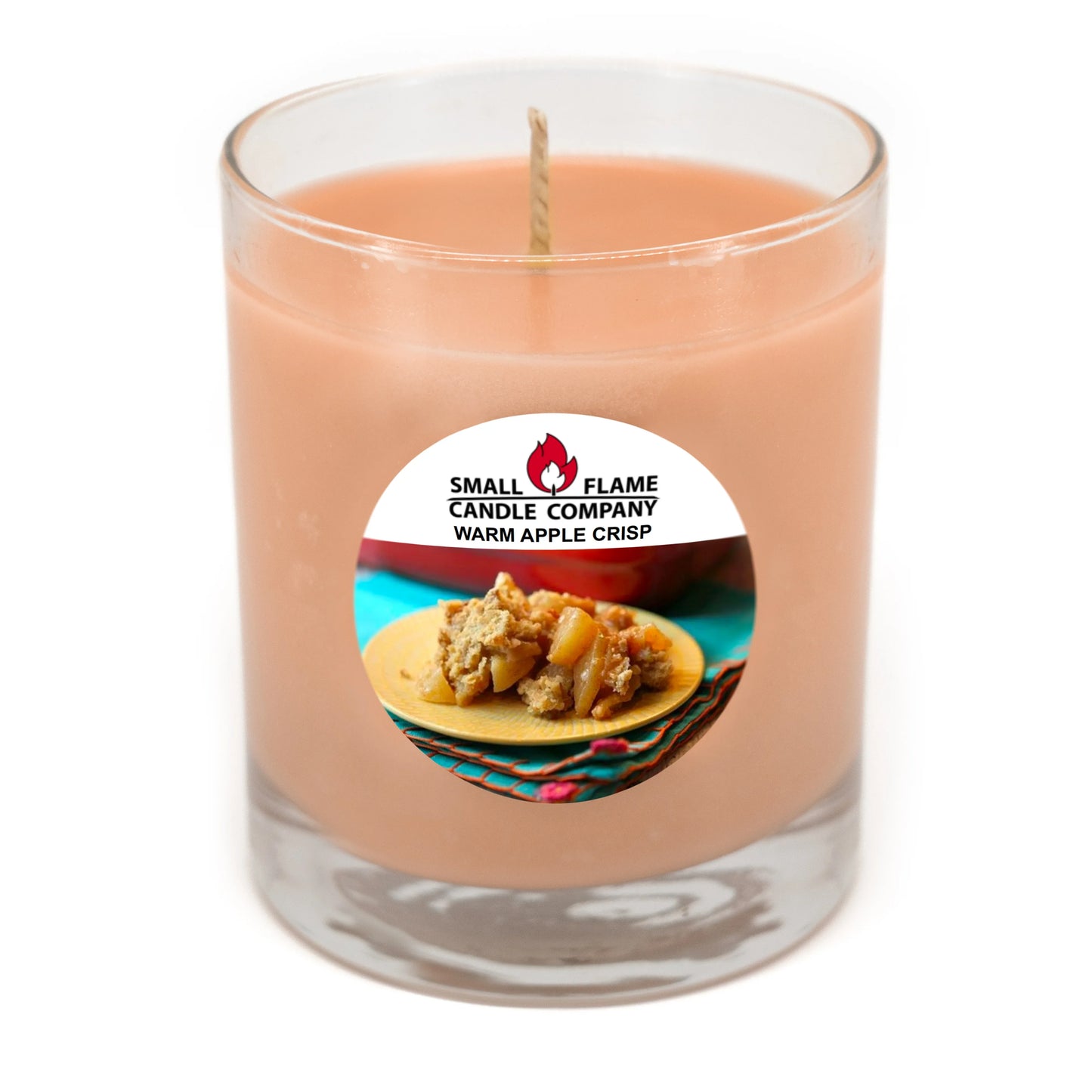 Warm apple crisp scented coconut-soy candle in glass jar with dessert label.
