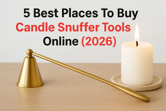 Gold candle snuffer tool next to a lit white candle on a wooden table