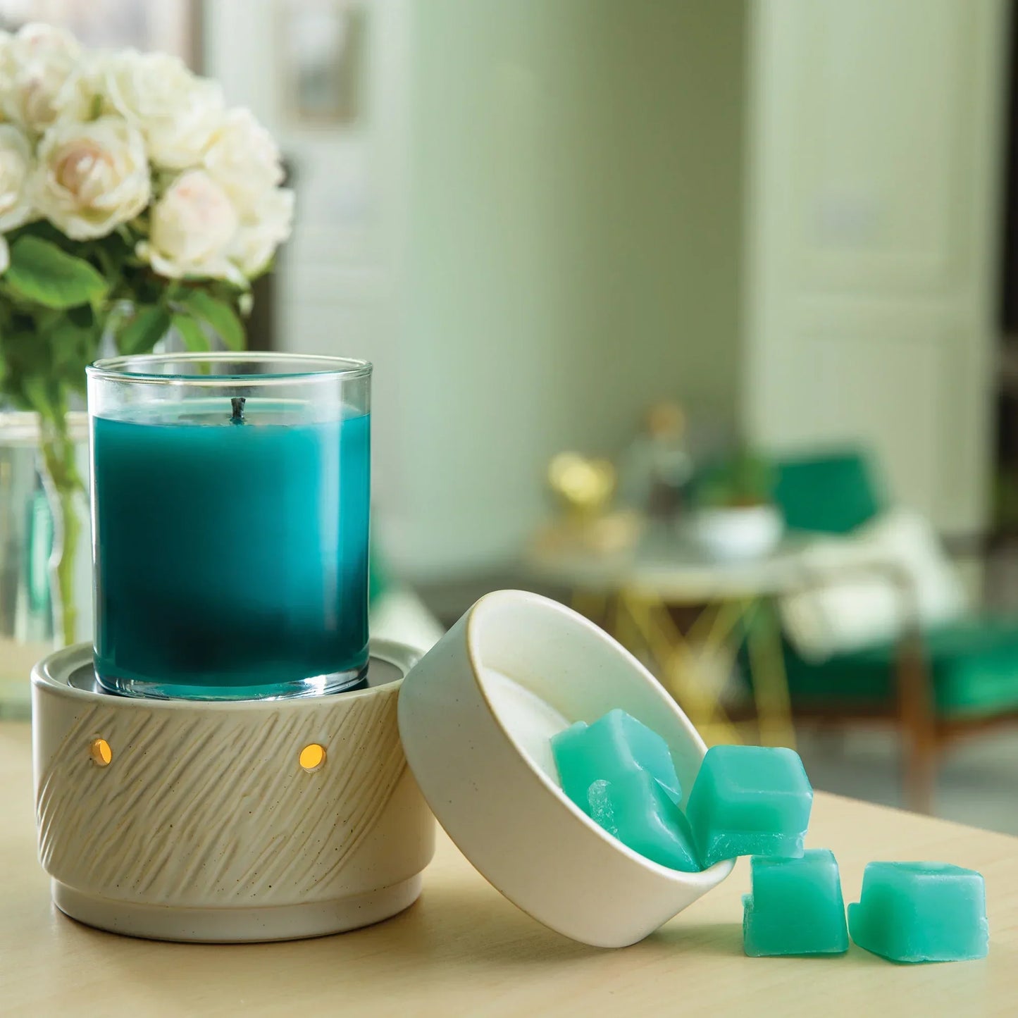 Teal coconut-soy candle in glass jar with matching wax melts and ceramic holder on table