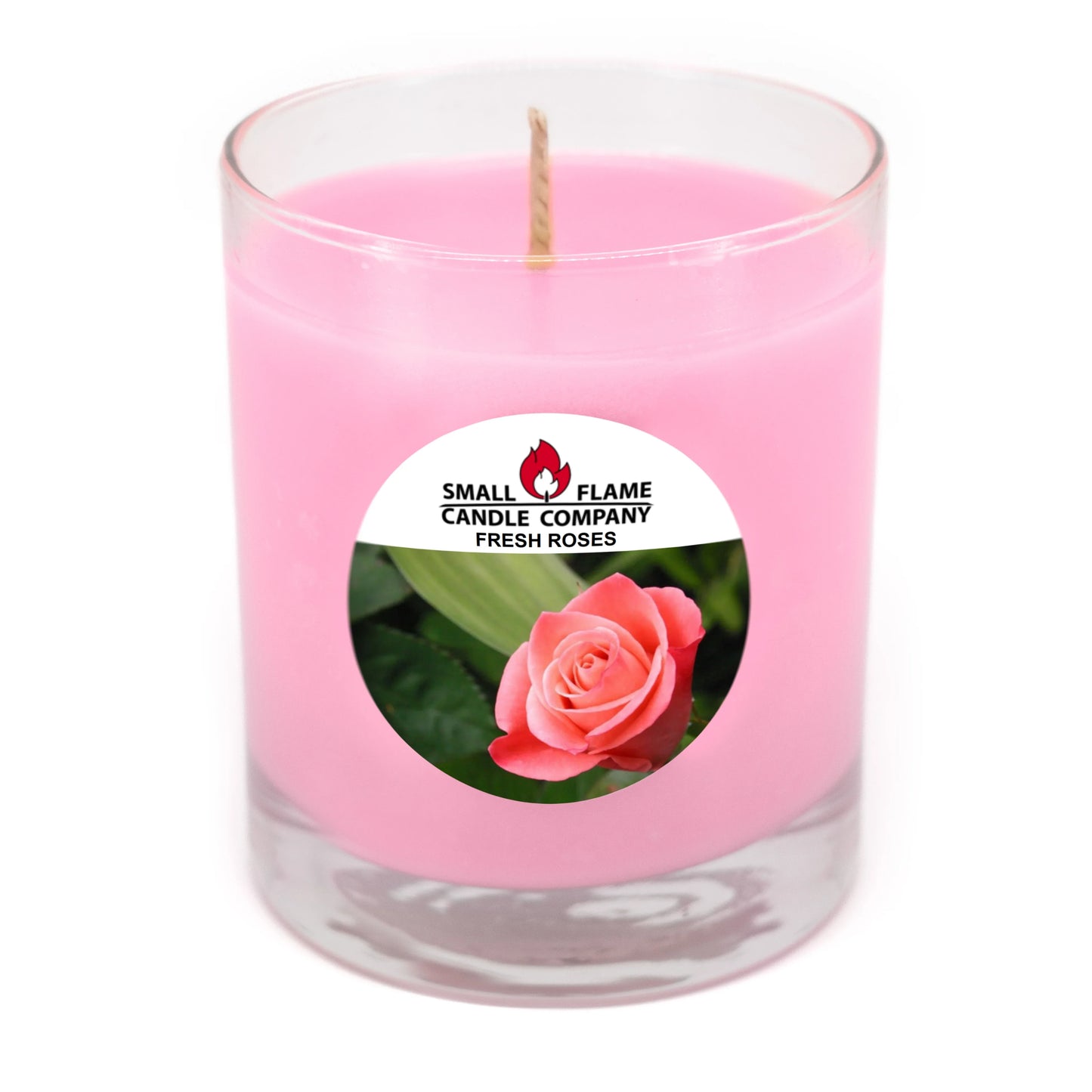 Pink rose-scented candle in clear glass jar with rose label and cotton wick