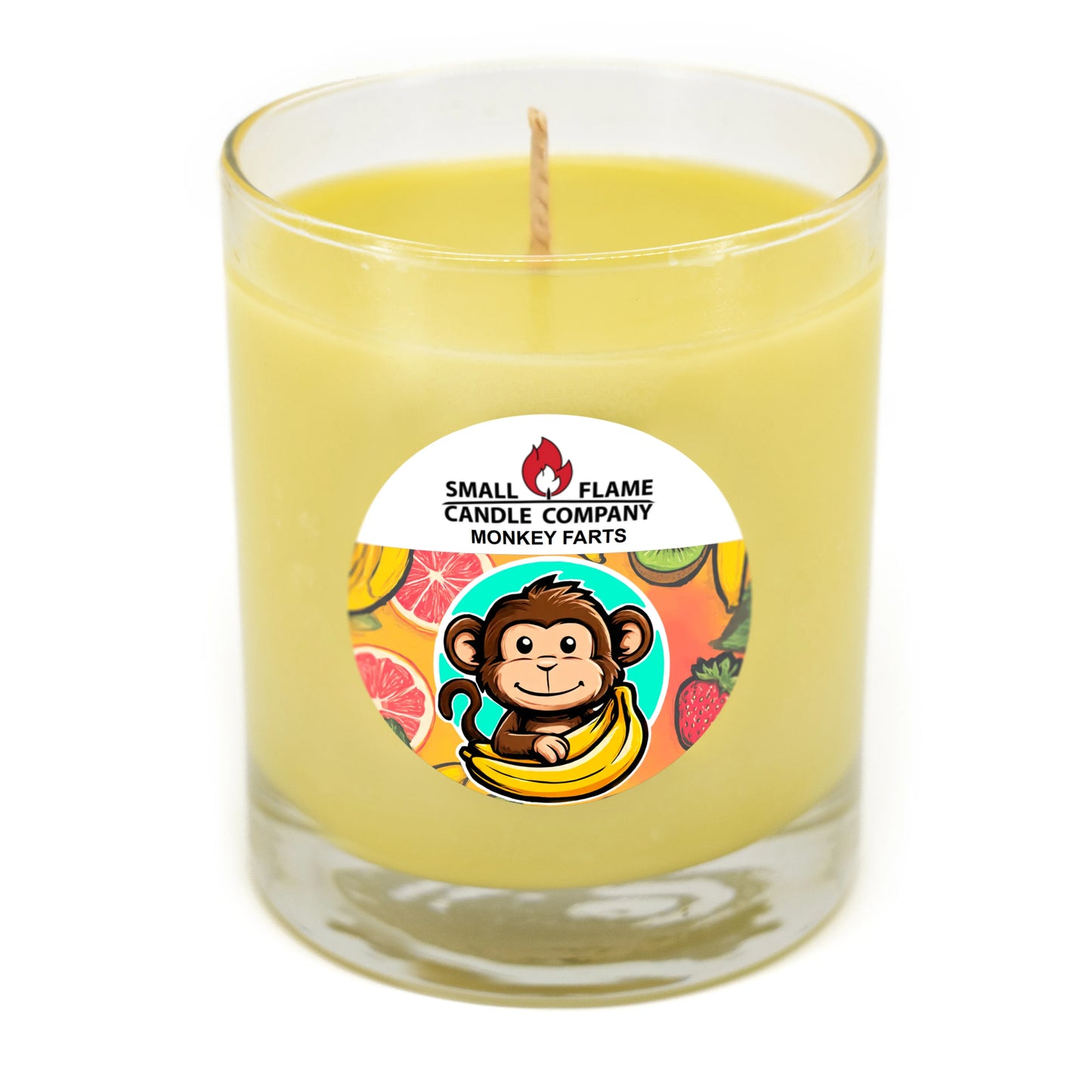 Yellow coconut-soy candle in glass jar with monkey and fruit label, Monkey Farts scent.