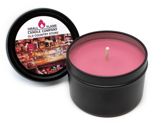 Pink coconut-soy wax candle in black tin with Old Country Store label, lid open