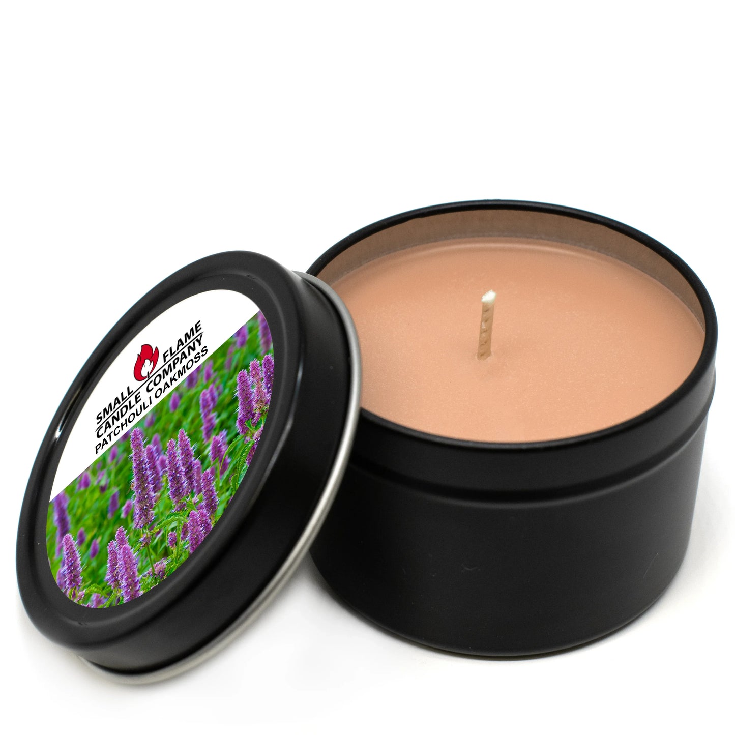 Patchouli Oakmoss coconut-soy candle in a black tin with floral label and open lid