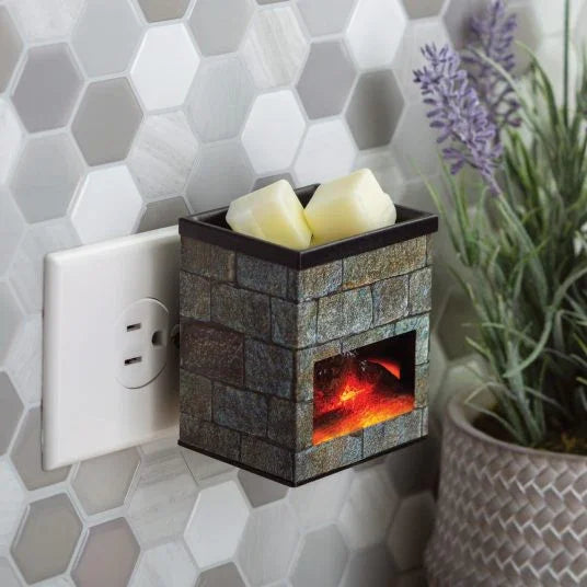 Electric wax melt warmer with stone fireplace design, plugged into a wall outlet