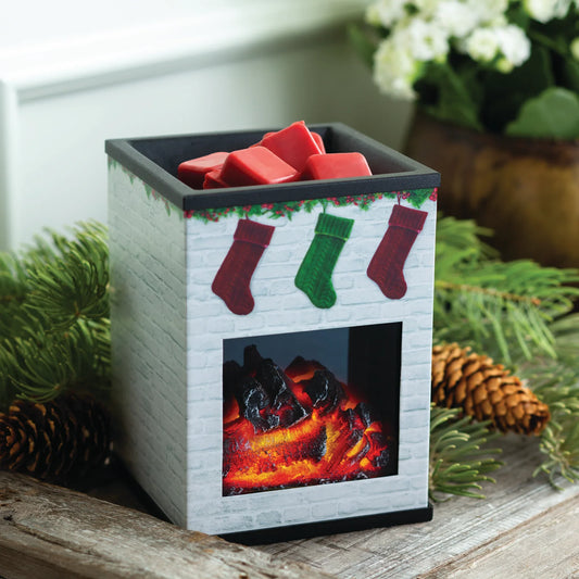 The Holiday Fireplace Illumination has a cozy fireplace design with three stockings, red wax melts, faux flames, pine branches, pinecones, and white flowers—perfect for adding festive fragrance to your home.