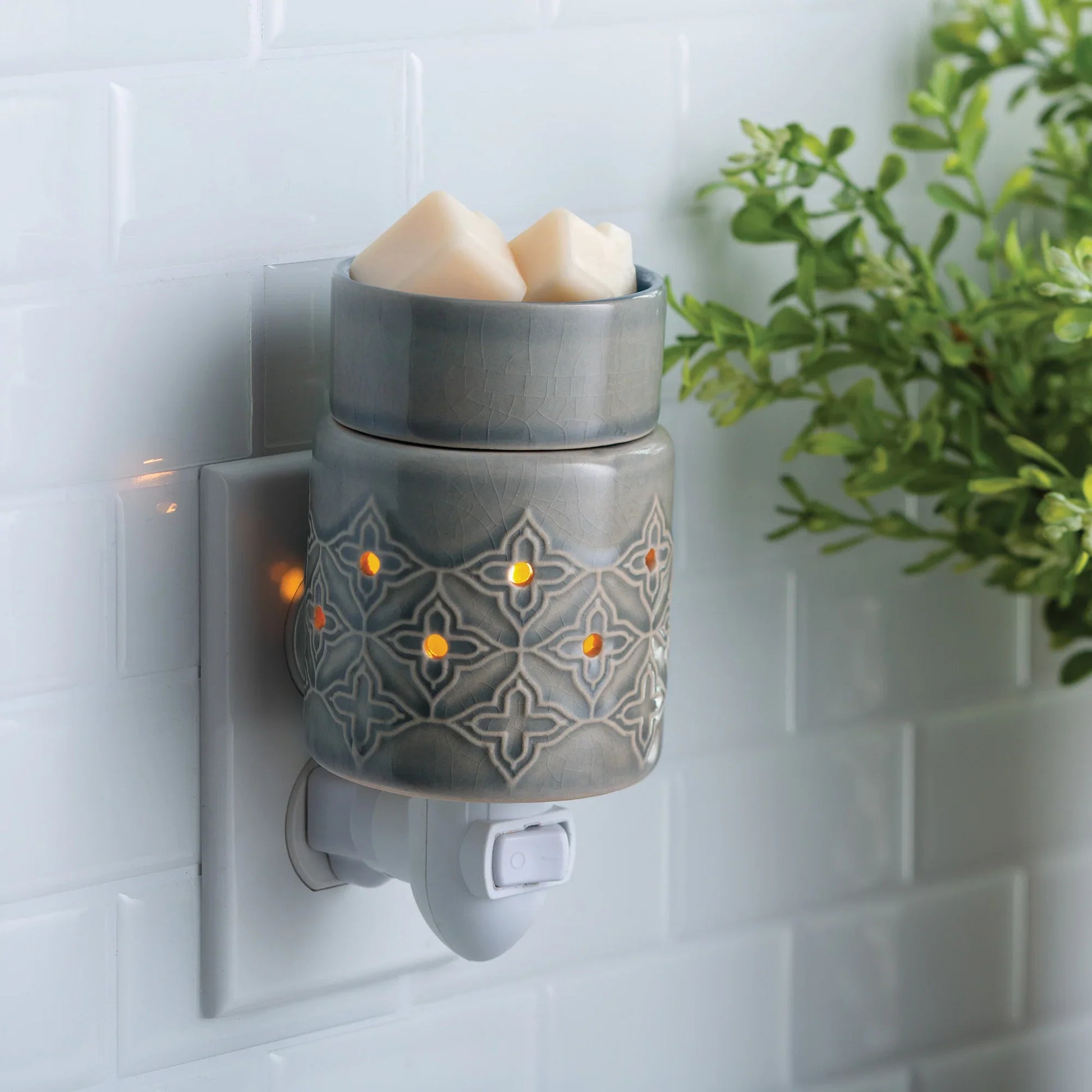 Plug-in ceramic wax melt warmer with geometric pattern, glowing lights, and wax cubes